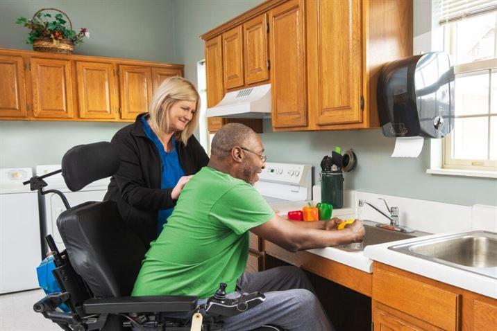 Patient working with physical therapist in kitchen